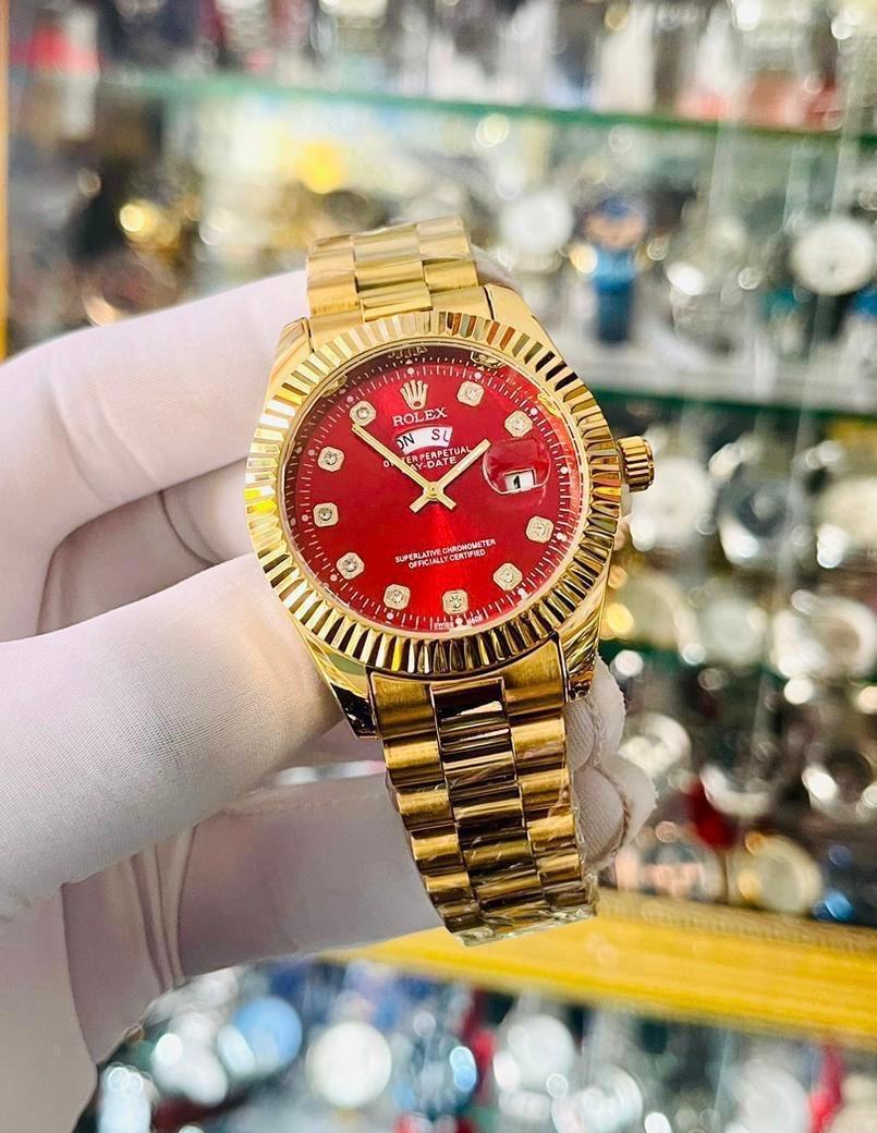 Montre rolex dorée fond rouge