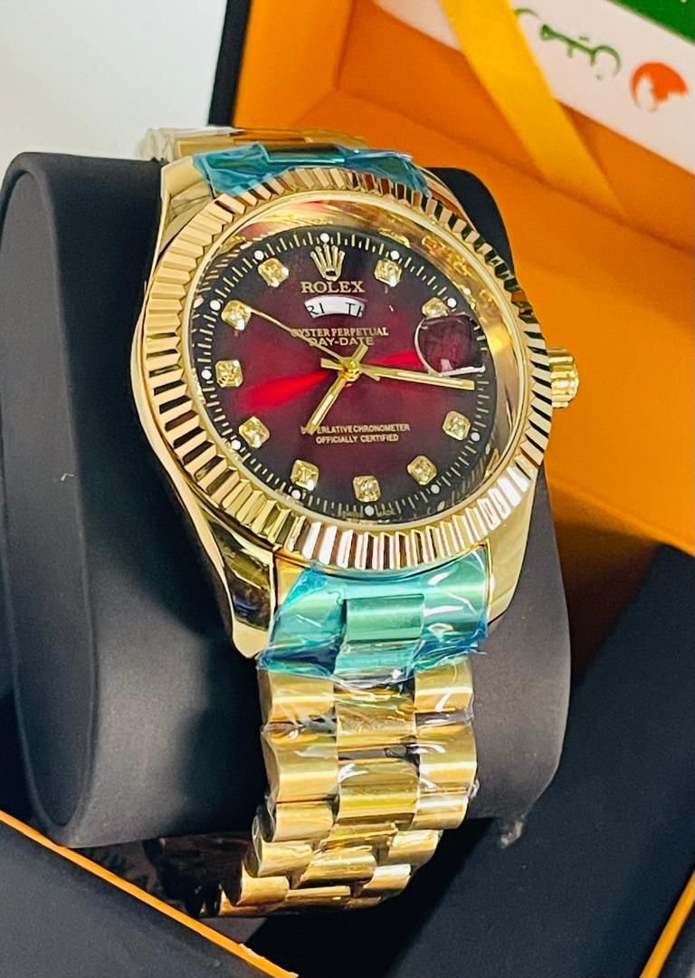 Montre rolex dorée fond rouge